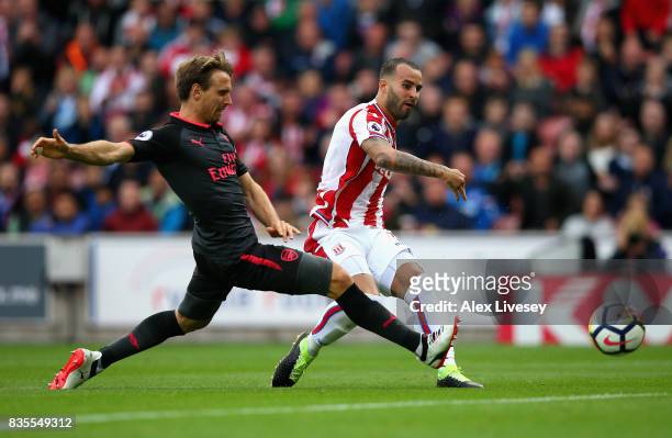 Jese of Stoke City scores his sides first goal as Nacho Monreal of Arsenal attempts to block during the Premier League match between Stoke City and...