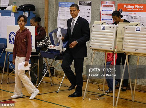 Democratic presidential nominee U.S. Sen. Barack Obama and his wife, Michelle Obama , carry their ballots to the tabulation machine with their...