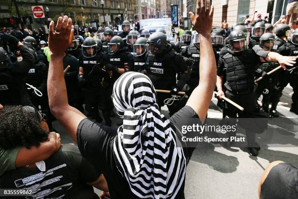 Protesters face off with riot police escorting conservative activists following a march in Boston against a planned 'Free Speech Rally' just one week...