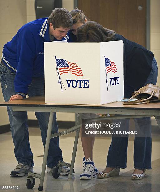 Melissa James shows her son Ryan and daughter McKenna the process of voting on Election Day November 04 at Centreville High School in Clifton,...