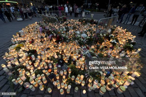 Candles and flowers have been left at the makeshift memorial for the victims of Friday's stabbings at the Turku Market Square, Finland on August 19,...