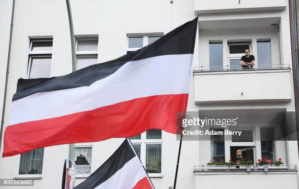 Residents look on as Neo-Nazis march with the original German Reich flag, the same colors as the banned Nazi flag, at an extreme right-wing...