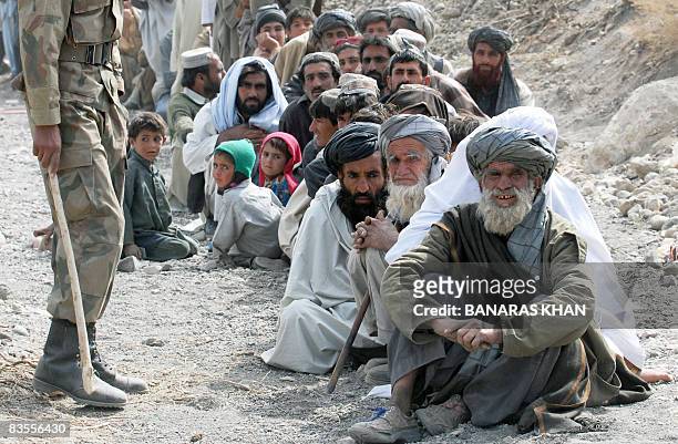 Pakistani earthquake survivors wait for relief supplies at a hilly area of Wam, one of about eight sparsely populated villages surrounding the town...
