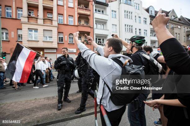 Counter demonstrators gesture towards participants affiliated with Neo-Nazi and extreme right groups at they marched through the street of Berlin's...