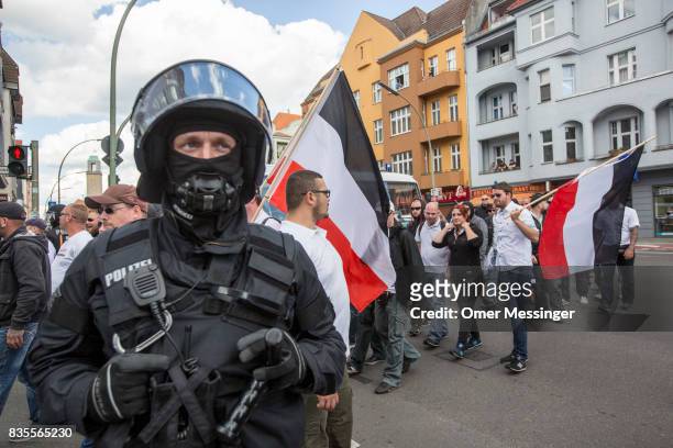 Participants in a Neo-Nazi march pass by a German riot policeman , on August 19, 2017 in Berlin, Germany. Some 1000 participants affiliated with...