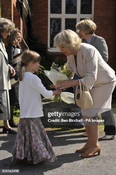 The Duchess of Cornwall accepts a posie from Ellen Coles, aged six from Oxford, during her visit to the Exmoor Pony Centre in Exmoor, Somerset.