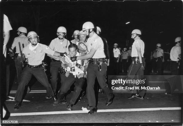 New York Times photographer Barton Silverman struggles to hold onto his cameras as he is arrested by police on Michigan Avenue during the Democratic...