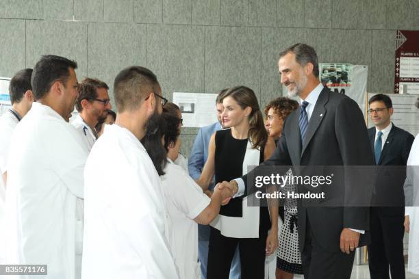 In this handout photo provided by Casa de S.M. El Rey de Espana, King Felipe VI of Spain and Queen Letizia of Spain meets with medical staff as they...