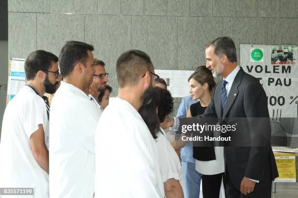 In this handout photo provided by Casa de S.M. El Rey de Espana, King Felipe VI of Spain and Queen Letizia of Spain meets with medical staff as they...