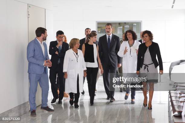 In this handout photo provided by Casa de S.M. El Rey de Espana, King Felipe VI of Spain and Queen Letizia of Spain walk with medical staff as they...
