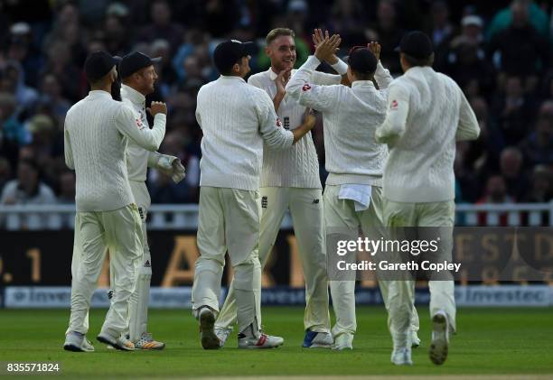 Stuart Broad of England celebrates with teammates after dismissing West Indies captain Jason Holder during day three of the 1st Investec Test between...