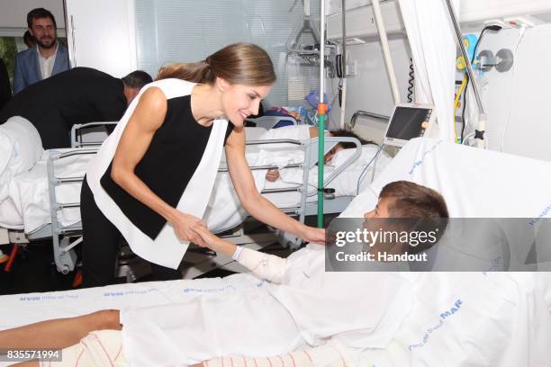 In this handout photo provided by Casa de S.M. El Rey de Espana, Queen Letizia of Spain visits a victim of last Thursday's terrorist attack at the...