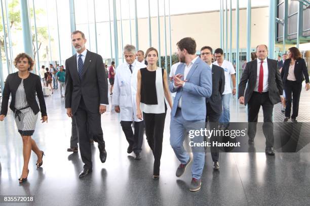 In this handout photo provided by Casa de S.M. El Rey de Espana, King Felipe VI of Spain and Queen Letizia of Spain speak with medical staff before...