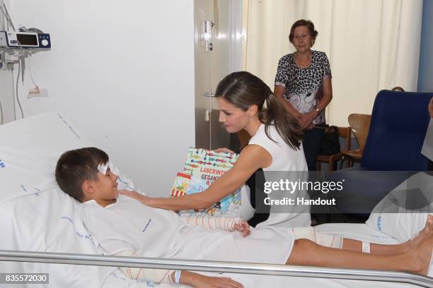 In this handout photo provided by Casa de S.M. El Rey de Espana, Queen Letizia of Spain visits a victim of last Thursday's terrorist attack at the...