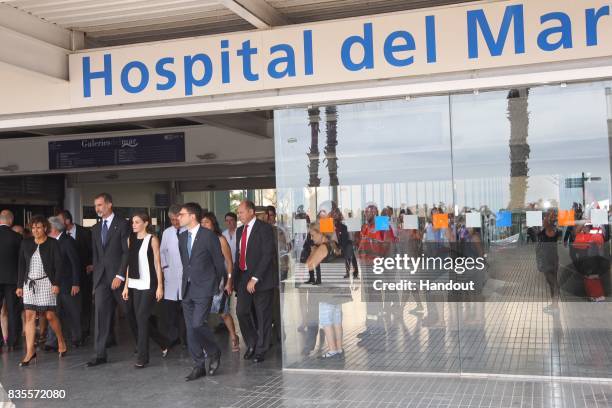 In this handout photo provided by Casa de S.M. El Rey de Espana, King Felipe VI of Spain and Queen Letizia of Spain walk with medical staff after hey...