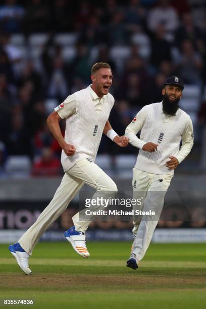 Stuart Broad of England celebrates with Moeen Ali after capturing the wicket of Jason Holder during day three of the 1st Investec Test match between...