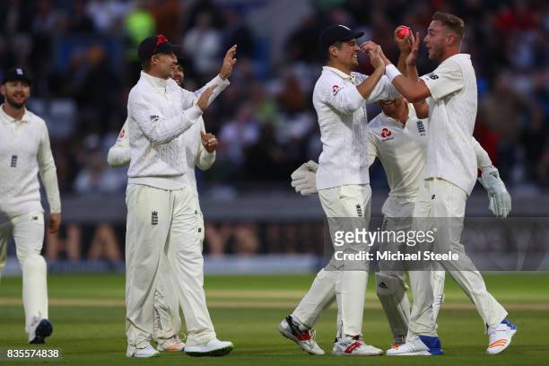 Stuart Broad of England celebrates with Alastair Cook after capturing the wicket of Jason Holder during day three of the 1st Investec Test match...