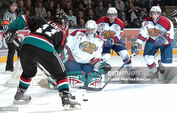 Colin Long of the Kelowna Rockets takes a shot on Torrie Jung, Tyler Hlookoff and Henrik Tervonen of the Edmonton Oil Kings at the Kelowna Rockets on...