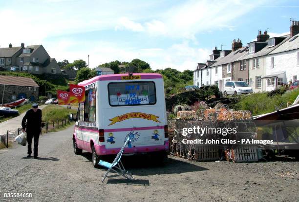 An ice cream van finds a spot next to lobster pots at Craster harbour on the north east coast.