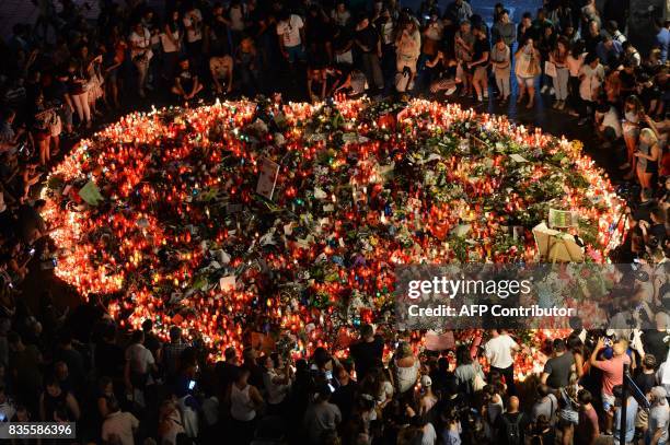 People pay tribute to the victims of the Barcelona attack on Las Ramblas boulevard in Barcelona on August 19 two days after a van ploughed into the...