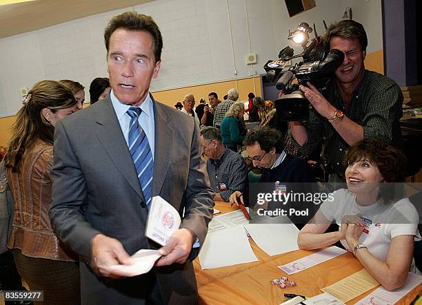 California Gov. Arnold Schwarzenegger C) heads towards the voting booth at Kenter Canyon Elementary school in Brentwood November 4, 2008 in Los...