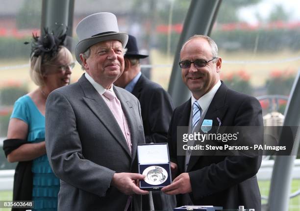 Trainer Richard Fahey is presented with his medal by John Sargeant after the King George V Stakes Heritage Handicap during ladies day at Ascot...