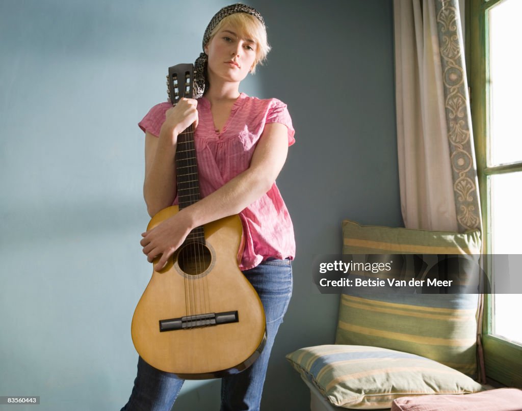 Portrait of young woman with guitar.