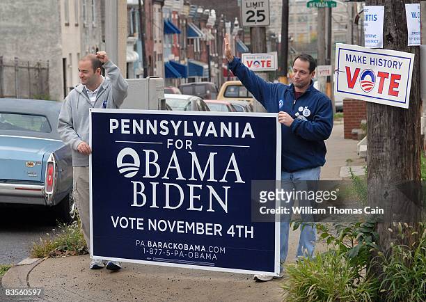 Jason Denker , of Stamford, Connecticut and Geoff Schneider , of Wilton, Connecticut hold a sign supporting Obama as they walk through a neighborhood...
