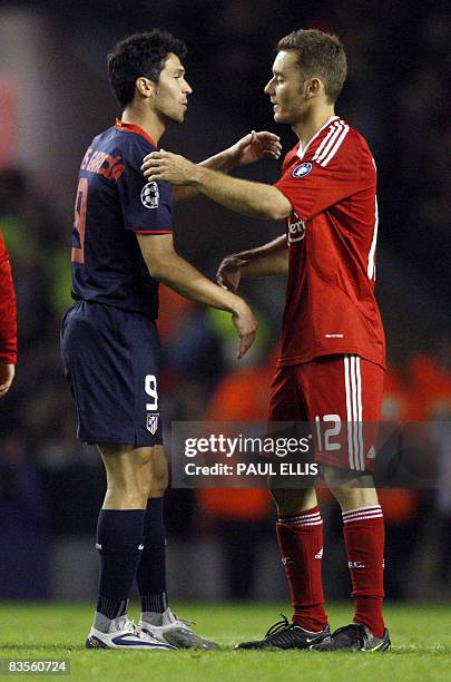 Former Liverpool player, Atletico Madrid's Spanish midfielder Luis García shakes hands with Liverpool's Brazilian defender Fabio Aurelio after their...