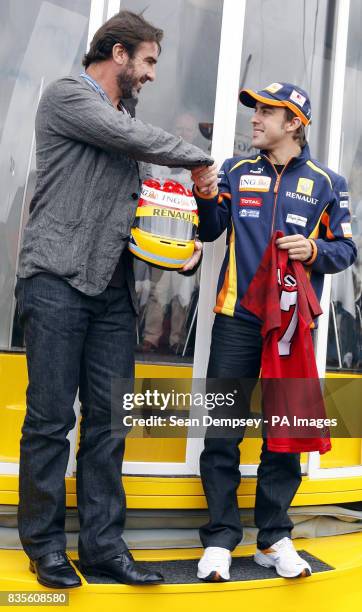 Eric Cantona shakes hands with Renault's Fernando Alonso during a photocall prior to the British Grand Prix at Silverstone, Northamptonshire.