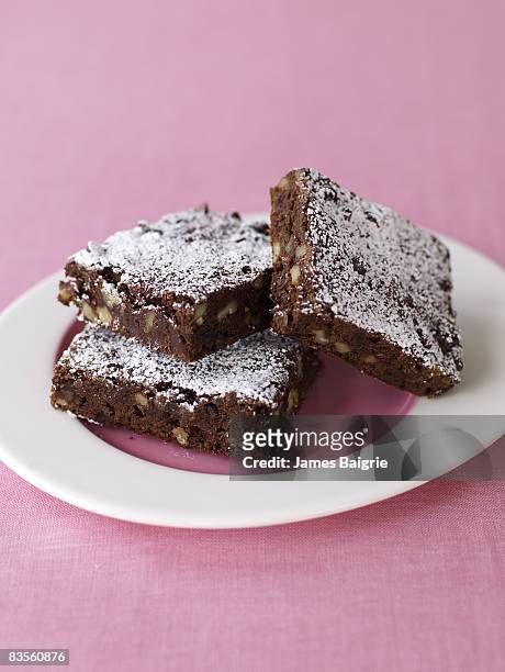chocolate brownies on pink background - brownie stockfoto's en -beelden