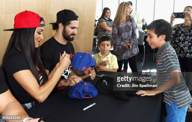 Nikki Bella and Seth Rollins greet a wish kid at the WWE Superstars Surprise Make-A-Wish Families at One World Observatory on August 19, 2017 in New...