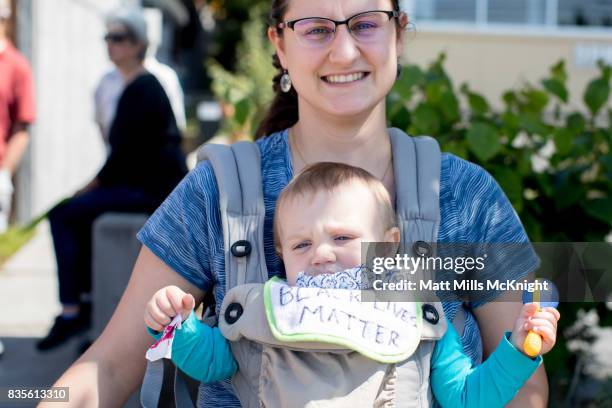 Katie McGee and her two-month-old son Nathan are seen along the sidewalk outside of Google's offices during an anti-Trump protest on August 19, 2017...