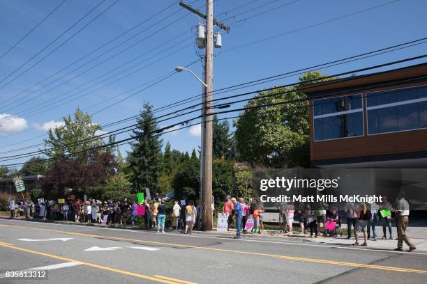 Demonstrators stand along the sidewalk across the street from Google's offices during an anti-Trump protest on August 19, 2017 in Kirkland,...