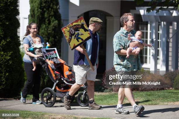 Demonstrators walk along the sidewalk outside of Google's offices during an anti-Trump protest on August 19, 2017 in Kirkland, Washington. The...