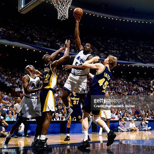 Shaquille O'Neal of the Orlando Magic goes up for a shot against Rick Smits and Dale Davis of the Indiana Pacers in Game One of the 1995 NBA Eastern...