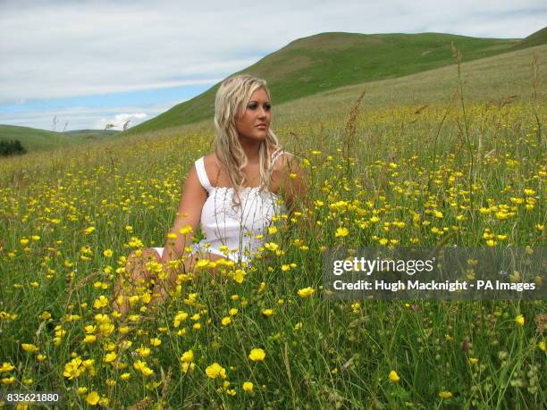 Shannon Waring relaxes in a rare ancient hay meadow now in full bloom at Barrowburn Farm in the Upper Coquet Valley part of the Cheviot Hills in...