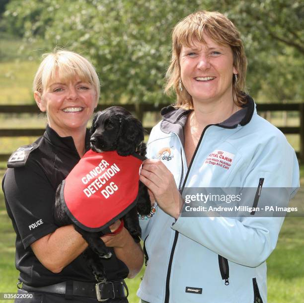 Sergeant Tracy Reid, of Strathclyde Police hands over Copper a nine week old Cocker Spaniel, to Claire Guest Director of Operations from the charity...