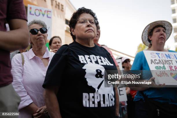 Woman wears a shirt advocating for the impeachment of President Donald Trump at a rally against white nationalism on August 19, 2017 in Mountain...