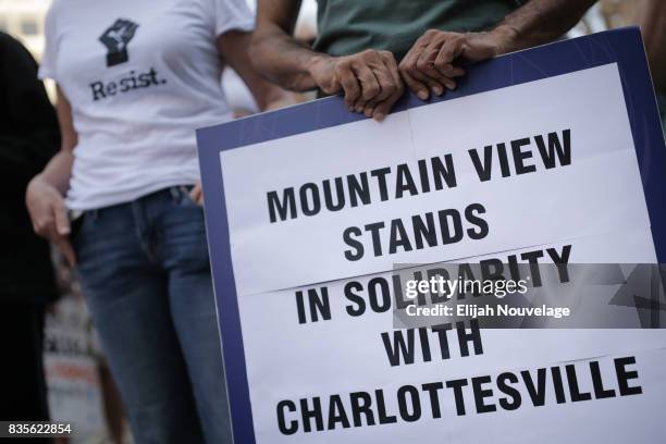 Man holds a sign indicating solidarity with Charlottesville at a rally against white nationalism on August 19, 2017 in Mountain View, California....