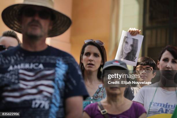 Man holds up a photo of Heather Heyer, who was killed last week in Charlottesville, Va., at a rally against white nationalism on August 19, 2017 in...