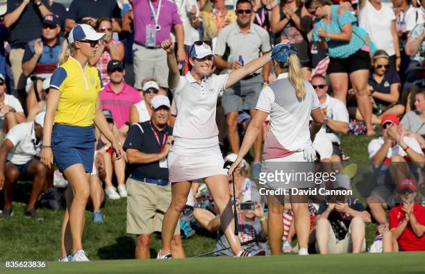 Paula Creamer of the United States Team celebrates with Austin Enrst on the 17th green after thier win against KArine Icher and Madelene Sagstrom of...