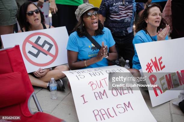 Women hold signs with opposing President Donald Trump and racism at a rally against white nationalism on August 19, 2017 in Mountain View,...