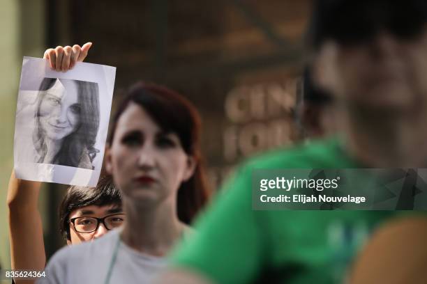 Man holds up a photo of Heather Heyer, who was killed last week in Charlottesville, Va., at a rally against white nationalism on August 19, 2017 in...