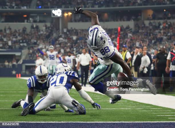 Dez Bryant of the Dallas Cowboys twists away from Darius Butler of the Indianapolis Colts to score a touchdown in the first quarter of a preseason...