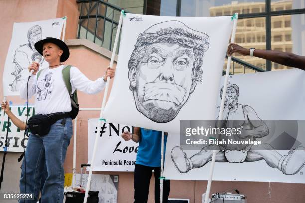 Artist Kira Od, of Sunnyvale, speaks at a rally against white nationalism while pieces of her original anti-Trump art is displayed behind her on...