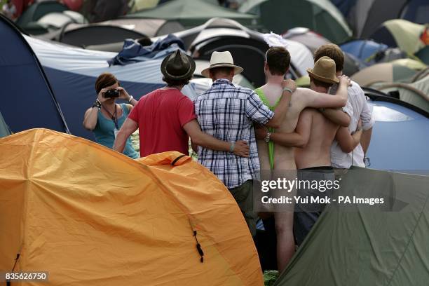 Festival goers pose for pictures with a man wearing a mankini during the 2009 Glastonbury Festival at Worthy Farm in Pilton, Somerset.