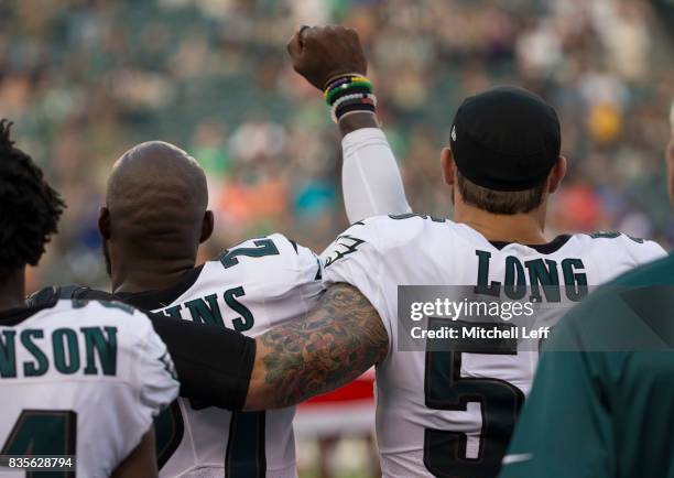 Malcolm Jenkins of the Philadelphia Eagles holds his fist in the air during the national anthem while Chris Long of the Philadelphia Eagles puts his...