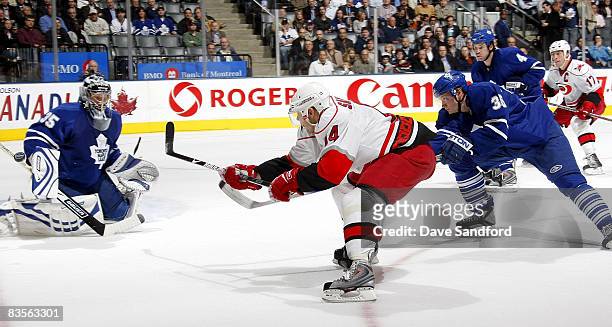 Vesa Toskala of the Toronto Maple Leafs positions himself for a save on Sergei Samsonov of the Carolina Hurricanes while Anton Stralman of the...
