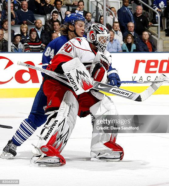 Mikhail Grabovski of the Toronto Maple Leafs puts a hold on Cam Ward of the Carolina Hurricanes during their NHL game at the Air Canada Centre...